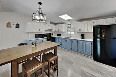 a kitchen with a wooden table and a black refrigerator at Put-in-Bay Island Club #21 in Put-in-Bay