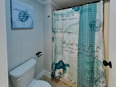 a bathroom with a shower curtain with writing on it at Put-in-Bay Island Club #22 in Put-in-Bay