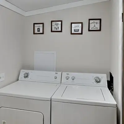 a white washing machine in a room with three pictures on the wall at Put-in-Bay Island Club #22 in Put-in-Bay