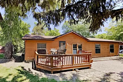 a log cabin with a deck and a table at Put-in-Bay Island Club #61 in Put-in-Bay