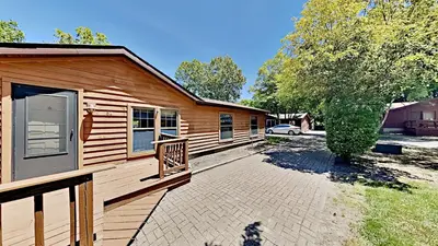 a cabin with a porch and a car parked next to it at Put-in-Bay Island Club #61 in Put-in-Bay