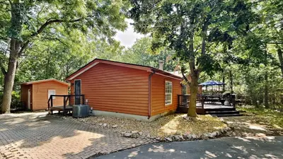 a small cabin in the woods with a tree at Put-in-Bay Island Club #95 in Put-in-Bay