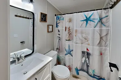 a bathroom with a shower curtain with a toilet and a sink at Put-in-Bay Island Club #106 in Put-in-Bay