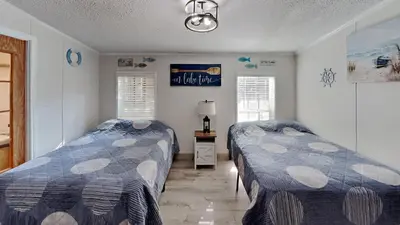 a bedroom with two beds and two windows at Put-in-Bay Island Club #108 in Put-in-Bay