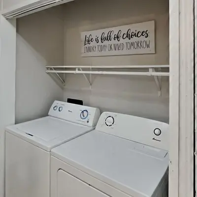 a laundry room with two washing machines and a sign at Put-in-Bay Island Club #108 in Put-in-Bay