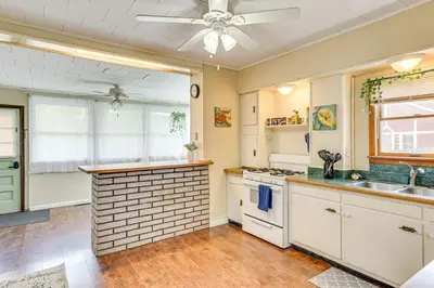 a kitchen with white cabinets and a ceiling fan at Walk to Medina Square, Historic 1880 Home in Medina
