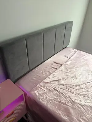 a bed with a head board and a pink mattress at Studio apartment with easy access to the city in Cleveland