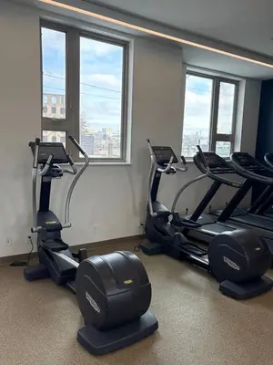 a gym with three treadmills and three windows at Studio apartment with easy access to the city in Cleveland