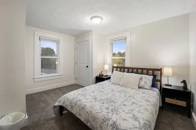 a bedroom with a bed and two windows at Newly Renovated Home <5 Mi to WEC! in Wilmington
