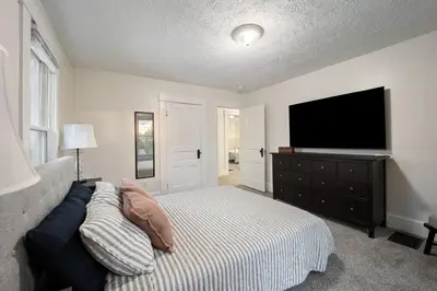 a bedroom with a bed and a flat screen tv at Newly Renovated Home <5 Mi to WEC! in Wilmington