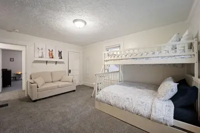 a bedroom with a bunk bed and a chair at Newly Renovated Home <5 Mi to WEC! in Wilmington