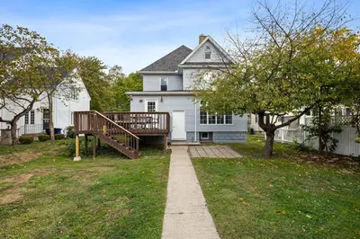 a white house with a porch and a wooden deck at Newly Renovated Home <5 Mi to WEC! in Wilmington