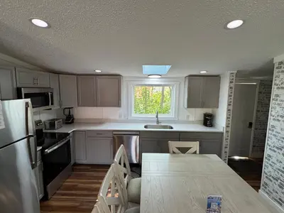 a kitchen with white cabinets and a sink and a window at Put-in-Bay Island Club #62 in Put-in-Bay