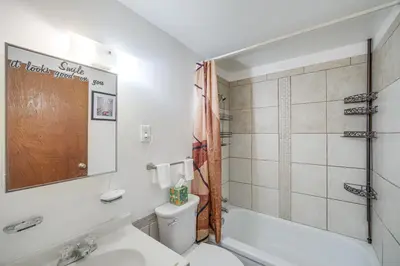 a bathroom with a toilet and a tub and a sink at Red Line to Downtown! Inviting Home in Cleveland in Cleveland