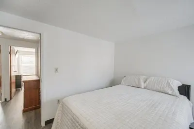 a white bedroom with a bed and a window at Red Line to Downtown! Inviting Home in Cleveland in Cleveland