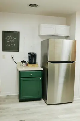 a kitchen with a stainless steel refrigerator and a green cabinet at Cozy bungalow in the heart of historic Marysville in Marysville