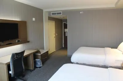 a hotel room with two beds and a flat screen tv at Courtyard by Marriott Muncie at Horizon Convention Center in Muncie