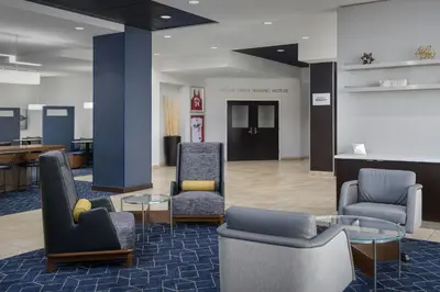 a lobby with chairs and a table and a desk at Courtyard by Marriott Muncie at Horizon Convention Center in Muncie