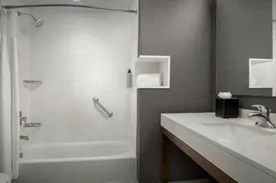 a bathroom with a sink and a tub and a toilet at Courtyard by Marriott Muncie at Horizon Convention Center in Muncie
