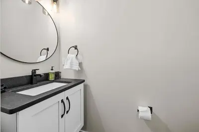 a bathroom with a sink and a mirror at Luxury Modern Lodge Near Fort Wayne with River Views