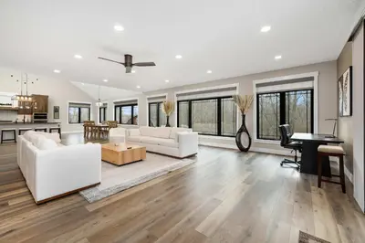 a living room with white furniture and a kitchen at Luxury Modern Lodge Near Fort Wayne with River Views