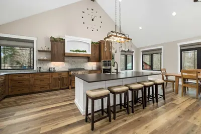 a kitchen with a large island with bar stools at Luxury Modern Lodge Near Fort Wayne with River Views