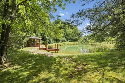 a park with a gazebo next to a pond at Breath of Heaven Cabin- Hot Tub, Deck, Pond, PETS in Logan
