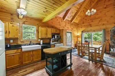 a kitchen with wooden walls and a wooden ceiling at Breath of Heaven Cabin- Hot Tub, Deck, Pond, PETS in Logan