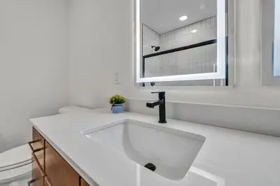 a white bathroom with a sink and a mirror at Little Italy & CWRU w King BedGymParkingWD in Cleveland
