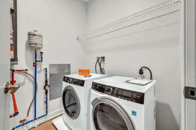 a laundry room with a washing machine in it at Little Italy & CWRU w King BedGymParkingWD in Cleveland