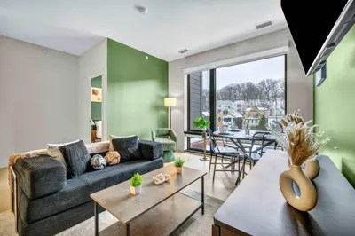 a living room with a couch and a table at Little Italy & CWRU w King BedGymParkingWD in Cleveland