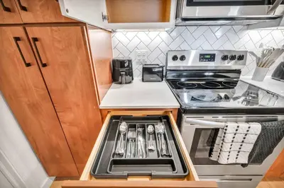 a small kitchen with a stove and an oven at Walk to CWRU w KingBed Balcony Gym Parking WD in Cleveland