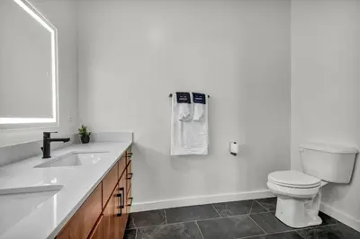 a white bathroom with a toilet and a sink at Walk to CWRU w KingBed Balcony Gym Parking WD in Cleveland