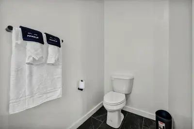 a bathroom with a toilet and towels on a wall at Walk to CWRU w KingBed Balcony Gym Parking WD in Cleveland
