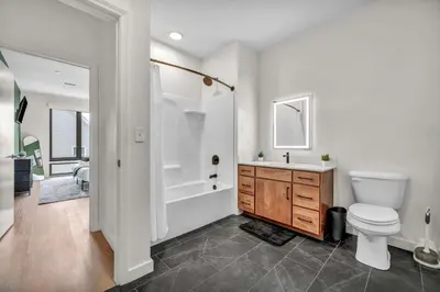 a bathroom with a toilet and a tub and a sink at Walk to CWRU w KingBed Balcony Gym Parking WD in Cleveland