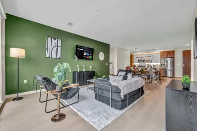 a living room with a bed and a green wall at Walk to CWRU w KingBed Balcony Gym Parking WD in Cleveland