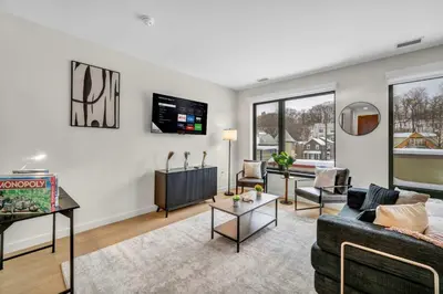 a living room with a couch and a tv at Cleveland Clinic w KingBed Balcony Gym Parking WD in Cleveland