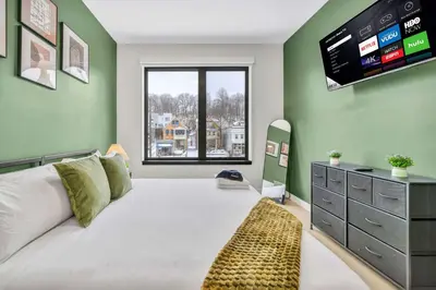 a bedroom with a large bed with a television on the wall at Cleveland Clinic w KingBed Balcony Gym Parking WD in Cleveland