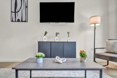 a living room with a table and a tv at Cleveland Clinic w KingBed Balcony Gym Parking WD in Cleveland
