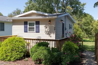 a small white house with a wooden fence at Perfectly Petite! in Ashland