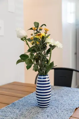 a blue and white striped vase with flowers on a table at Perfectly Petite! in Ashland