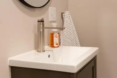 a bathroom sink with a soap dispenser on it at Perfectly Petite! in Ashland