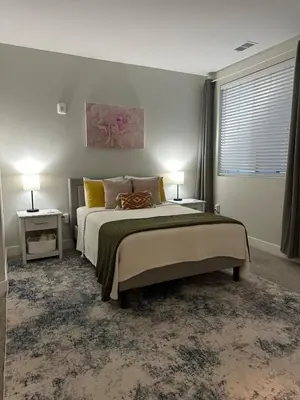 a bedroom with a bed and two lamps and a window at Modern apt in Cincy stadiums and with river views in Cincinnati