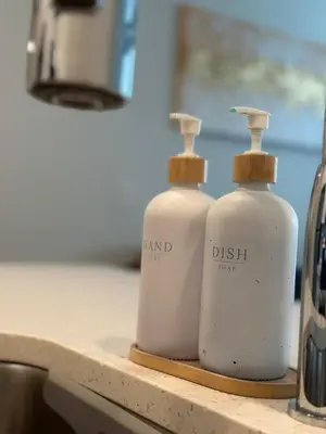 two white detergent bottles sitting on a kitchen counter at Modern apt in Cincy stadiums and with river views in Cincinnati