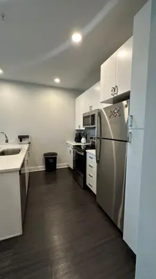 a kitchen with white cabinets and a refrigerator at Modern apt in Cincy stadiums and with river views in Cincinnati