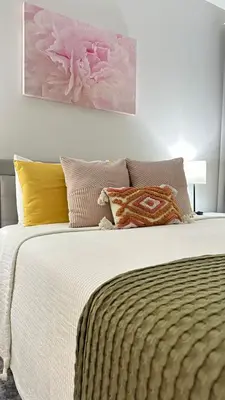 a bedroom with a large bed with colorful pillows at Modern apt in Cincy stadiums and with river views in Cincinnati