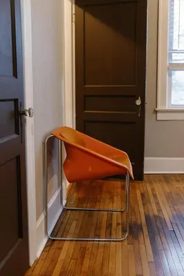 an orange chair sitting in front of a door at The Avon - Quaint Home in Downtown Lexington in Lexington