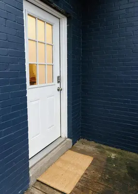 a white door in a blue brick wall at The Avon - Quaint Home in Downtown Lexington in Lexington