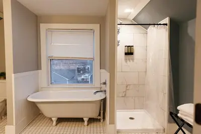 a bathroom with a tub and a shower and a window at The Avon - Quaint Home in Downtown Lexington in Lexington