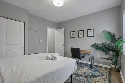 a bedroom with a bed and a desk and a chair at Modern 2BR Yale Townhouse Near Downtown Columbus in Columbus
